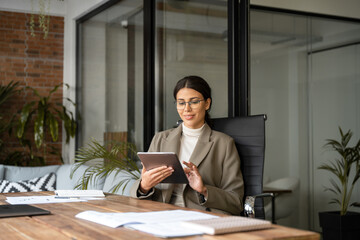 Young latin Hispanic professional business woman working on pad pc computer. Middle eastern...