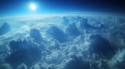 Fototapeta premium A breathtaking aerial view of fluffy white clouds illuminated by a radiant sun against a clear blue sky presenting a captivating celestial scene