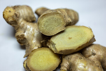 fresh raw ginger slice close-up studio shot with blurred white background