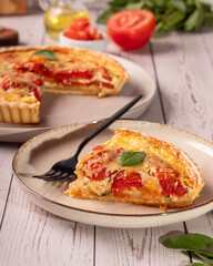 Quiche de tomate com queijo e manjericão, elementos como azeite, tomate e manjericão ao redor da cena