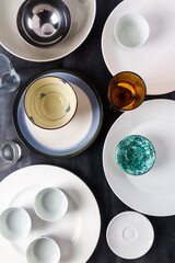 Top view of an empty plates, bowls and glasses placed on a black chalkboard background. Flat lay. Top view. Food concept.