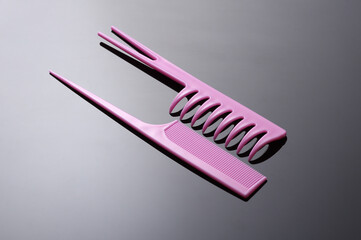 Set of pink plastic combs on black background