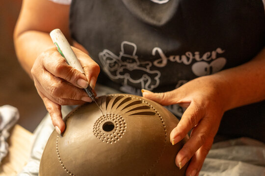 Woman's hands creating traditional pottery in Oaxaca, Mexico