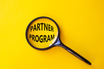 Partner Program symbol. Concept words Partner Program on magnifying glass. Beautiful yellow background. Business and Partner Program concept. Copy space.