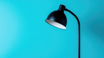 Modern black floor lamp against a vibrant turquoise background with ample copy space for text placement