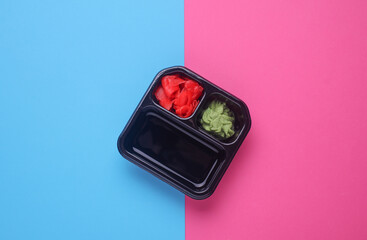 Tray with ginger, wasabi and soy sauce on pink blue background