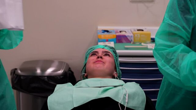 Dentist assistant placing cheek retractor while odontologist prepares camera