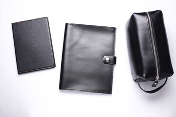 Black Leather notebook, folder, and cosmetic bag organizer on white background. Genuine leather products