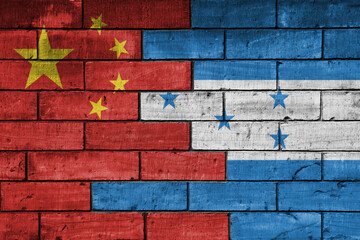 colourful painted big flag of china and flag of honduras on a massive old brick wall background....