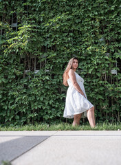 Young beautiful smiling woman in Virginia creeper in spring