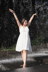 woman standing barefoot in falling water fountain