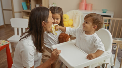 Mother and two children share a loving moment as the son offers a banana to his mother in a cozy bedroom setting, showcasing warm family bonds and togetherness.
