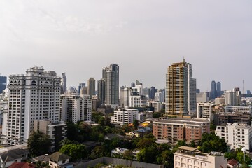 Fototapeta premium City skyline showcases Bangkok’s modern architecture amid urban greenery on a clear day