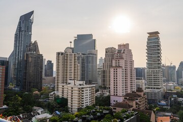 Obraz premium Cityscape of Bangkok featuring modern skyscrapers under a vibrant sunset sky