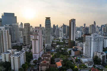 Fototapeta premium Vibrant skyline of Bangkok at dusk with modern buildings and a soft sunset glow illuminating the cityscape