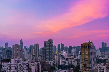 City skyline illuminated by colorful sunset hues over urban buildings in a bustling metropolis
