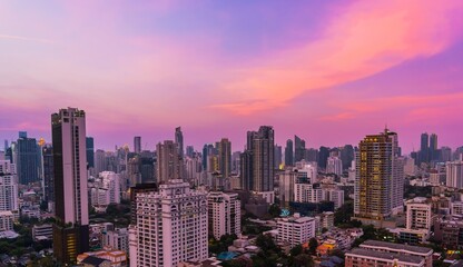Obraz premium Sunset over a bustling city skyline with colorful clouds and modern architecture