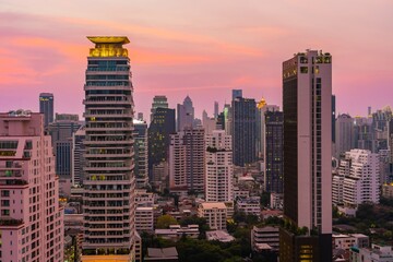 Obraz premium Stunning skyline view of Bangkok at sunset showcasing modern skyscrapers and vibrant colors in the sky