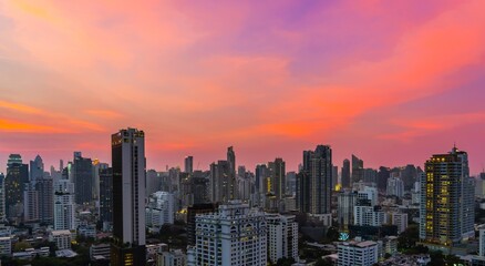 Fototapeta premium Vibrant sunset over a bustling city skyline with modern architecture and warm colors in the evening sky