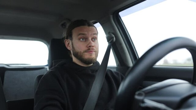 an emotional man driving a car