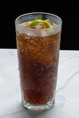 Drinks alcóolicos a base de bebidas destilada servidos sobre pedra de mármore e fundo preto.
