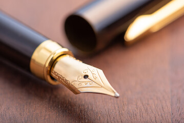 Fountain pen, beautiful fountain pen in detail on wooden surface, selective focus.