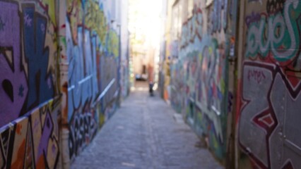Blurry street with colorful graffiti creating a vibrant urban alleyway, showcasing defocused art in an outdoor ghetto setting.