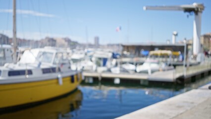 Fototapeta premium Blurry view of boats and marina in marseilles port with sunny skies and vibrant waterfront atmosphere showcasing nautical themes and french coastal life.