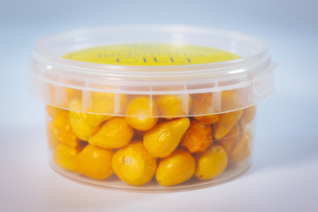A clear plastic container filled with vibrant yellow freeze-dried Argentine chili peppers. Perfect for long-term storage, cooking, or seasoning. Lightweight and shelf-stable.