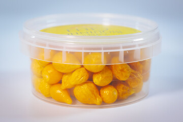A clear plastic container filled with vibrant yellow freeze-dried Argentine chili peppers. Perfect for long-term storage, cooking, or seasoning. Lightweight and shelf-stable.