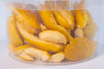 A clear container filled with freeze-dried quince pieces, highlighting their golden-yellow hue and natural texture. Perfect for snacking or adding to recipes.