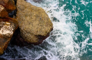 Sea wave rolling on the coast rocks