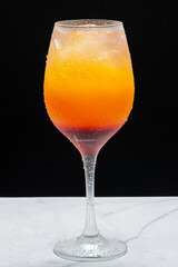 Drinks alcóolicos a base de bebidas destilada servidos sobre pedra de mármore e fundo preto.
