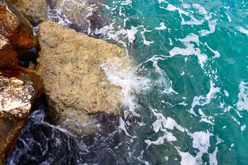 Obraz premium Sea wave rolling on the coast rocks