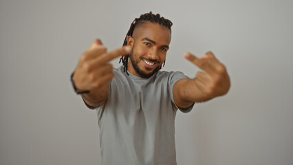Fototapeta premium Young man with braids showing middle fingers on an isolated white background confidently expressing nonconformity and style with a bold smile, showcasing personal attitude.