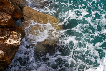 Sea wave rolling on the coast rocks