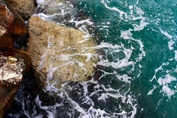 Sea wave rolling on the coast rocks