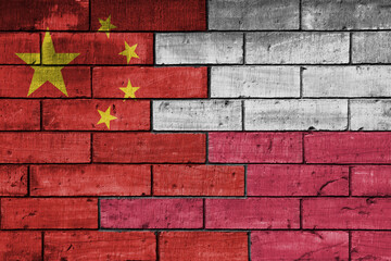 colourful painted big flag of china and flag of poland on a massive old brick wall background. concept