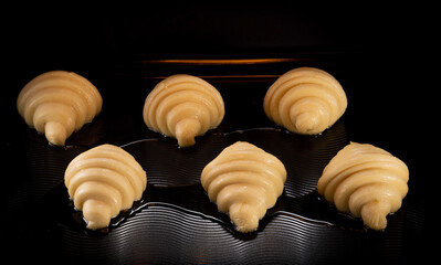 Homemade croissants baking in oven , close-up