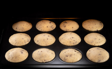 Tasty Homemade muffins baking in oven , close-up