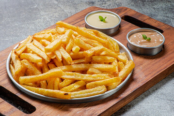 Porção de batatas fritas, servida com molho rosê e maionese