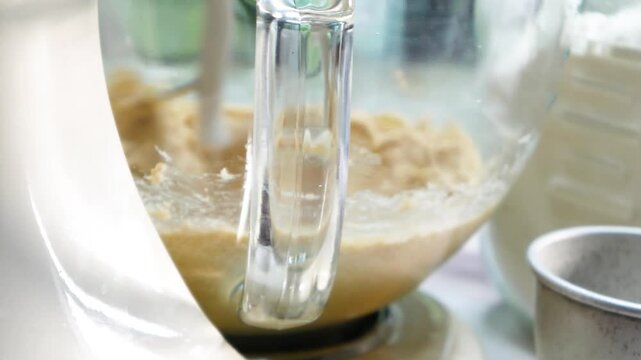 Making chocolate covered cookie dough as a dessert.  Mixing the cookie dough in bowl and rolling the dough into balls and dipping them in chocolate.