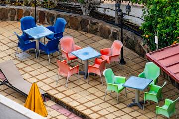 A colorful patio with a variety of chairs and tables