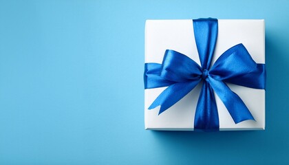 white present box with blue satin ribbon on smooth light blue background