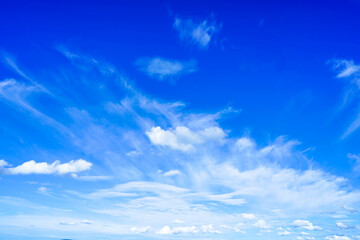 Fototapeta premium Ярко-голубое небо с тонкими кудрявыми облаками в солнечный, ясный день