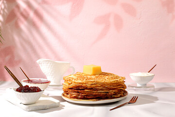 Delicious Russian pancakes with jam, soft cottage cheese and milk on a marble table. Healthy breakfast with ingredients, the concept of natural products and traditional national cuisine, 