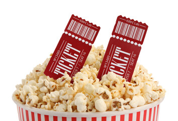 Tasty popcorn and movie tickets isolated on white