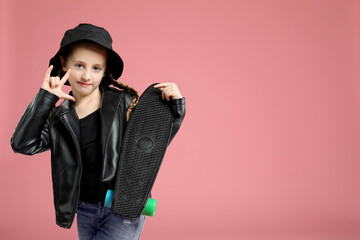 Little girl with penny board showing rock gesture on pink background, space for text