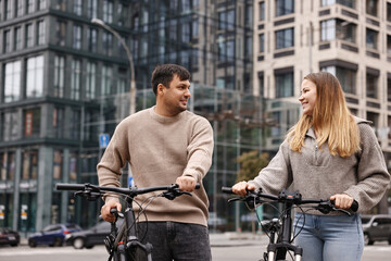 Obraz premium Beautiful happy couple with bicycles spending time together outdoors