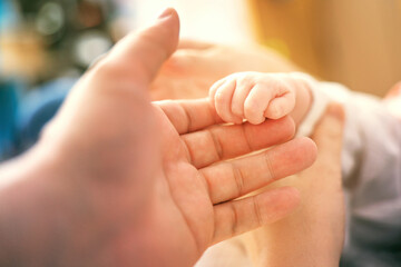 tender moment captured as a small child's hand gently holds their mother's finger, symbolizing love, trust, and connection in warm tones
